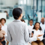 Rearview shot of an unrecognizable businesswoman giving a presentation in the office boardroom.