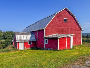 A big red old barn on a farm.