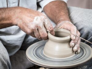 Someone making a vase on a pottery wheel.